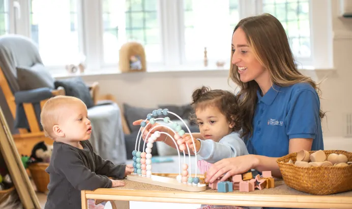 Key worker playing with young children at Little Acorns Day Nursery Preschool Stoneygate