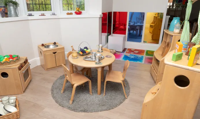 Little wooden table with play kitchen at Little Acorns Day Nursery Preschool Stoneygate