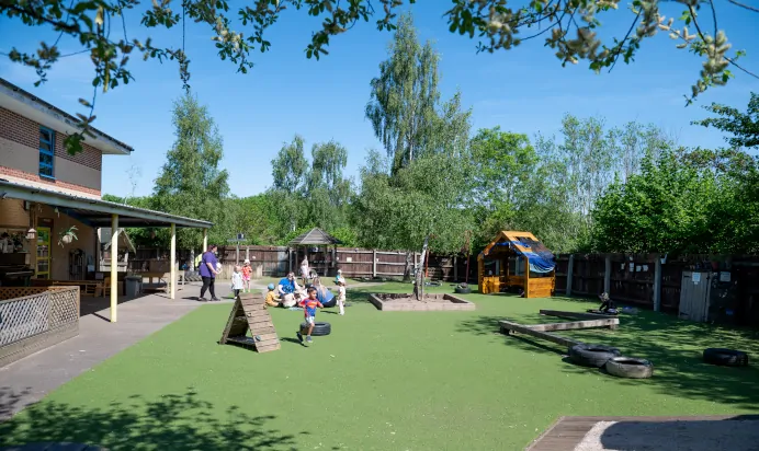 Outdoor area with children playing at Kiddi Caru Day Nursery Preschool Wellingborough