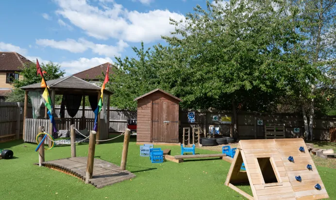 Outdoor play area with climbing frame at Kiddi Caru Day Nursery Preschool Walnut Tree Milton Keynes