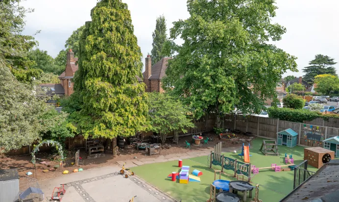 Outdoor play area with grass and tarmac at Little Acorns Day Nursery Preschool Stoneygate