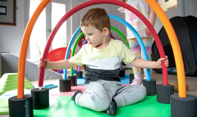 Rainbow hoops with child sat underneath at Charnwood Day Nursery Preschool Shepshed Loughborough