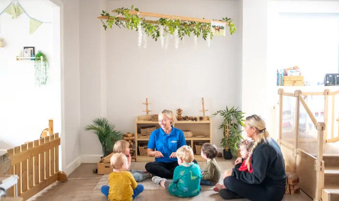 Young children sitting with key workers at Kiddi Caru Day Nursery Preschool Market Harborough