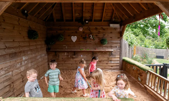 Children playing in a large sand pit at Kiddi Caru Day Nursery Preschool Fareham