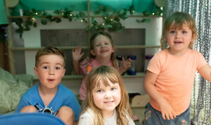 Children playing together and smiling at Kiddi Caru Day Nursery Preschool Market Ower