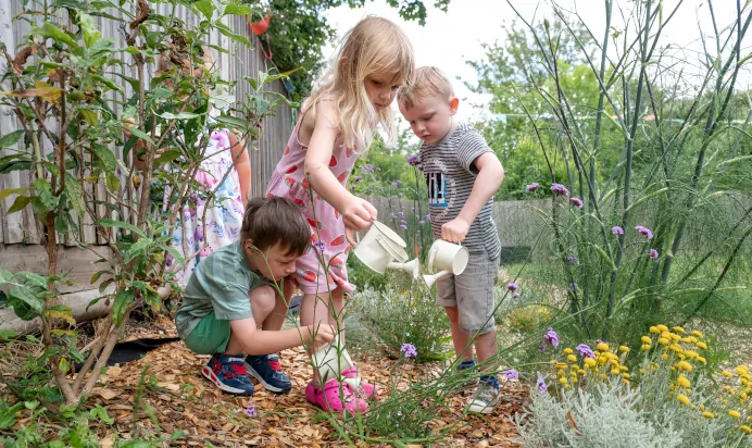 Children watering plants at Kiddi Caru Day Nursery Preschool Fareham