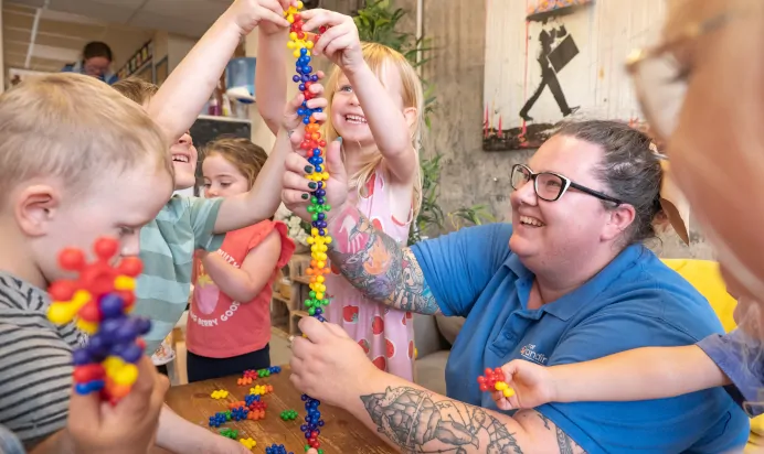 Key worker and children playing with toys at Kiddi Caru Day Nursery Preschool Fareham