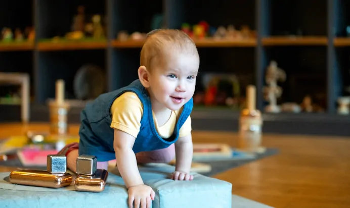 Child climbing on soft blocks at Dicky Birds Nursery Preschool Claremont Road Surbiton