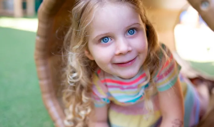 Child coming out of a play tunnel at Dicky Birds Nursery Preschool Claremont Road Surbiton