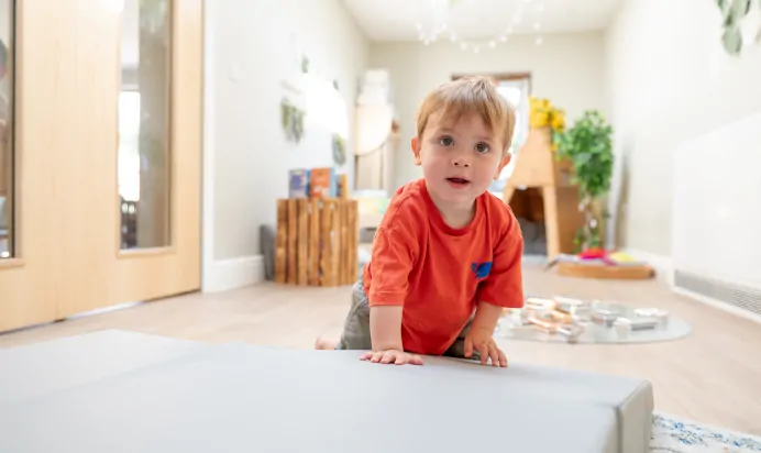 Child crawling indoors at Dicky Birds Nursery Preschool Pelham Road Wimbledon London