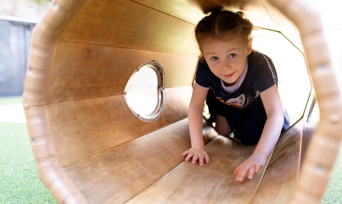 Child in play tunnel at Dicky Birds Nursery Preschool Claremont Road Surbiton