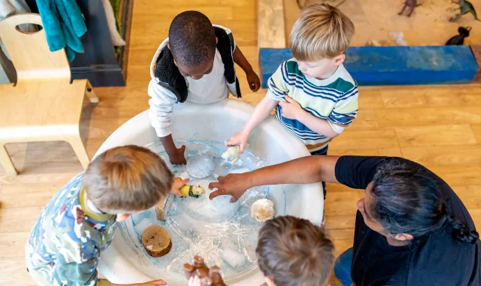 Children and key worker playing with water at Dicky Birds Nursery Preschool Claremont Road Surbiton
