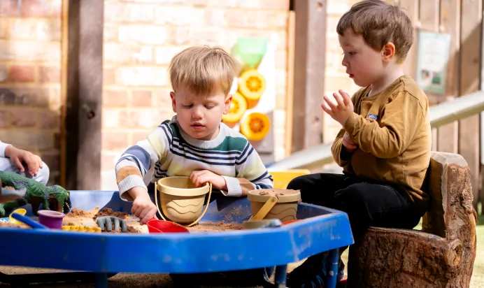Children building sand castles in sand pit at Dicky Birds Nursery Preschool Claremont Road Surbiton