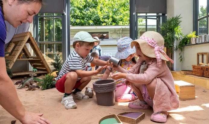 Children playing in indoor sand pit at Dicky Birds Nursery Preschool Queens Road Wimbledon London