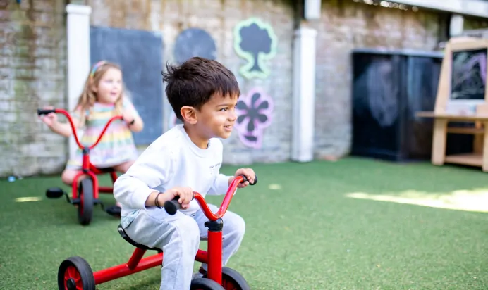 Children playing on trikes at Dicky Birds Nursery Preschool Claremont Road Surbiton