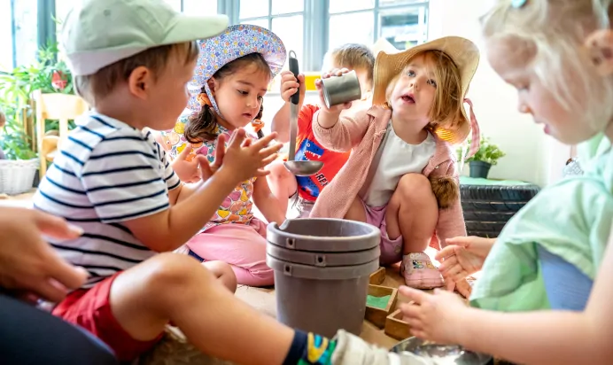 Children playing with water at Dicky Birds Nursery Preschool Queens Road Wimbledon London