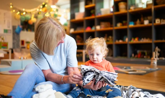 Key worker and child using sensory toy at Dicky Birds Nursery Preschool Claremont Road Surbiton