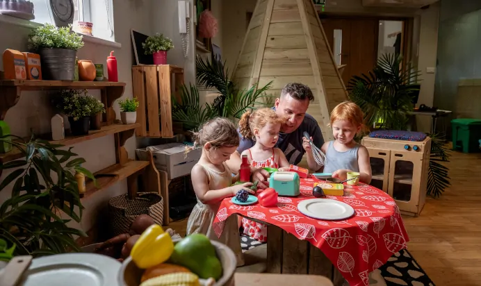 Key worker pretending to cook with children at Dicky Birds Nursery Preschool Raynes Park London