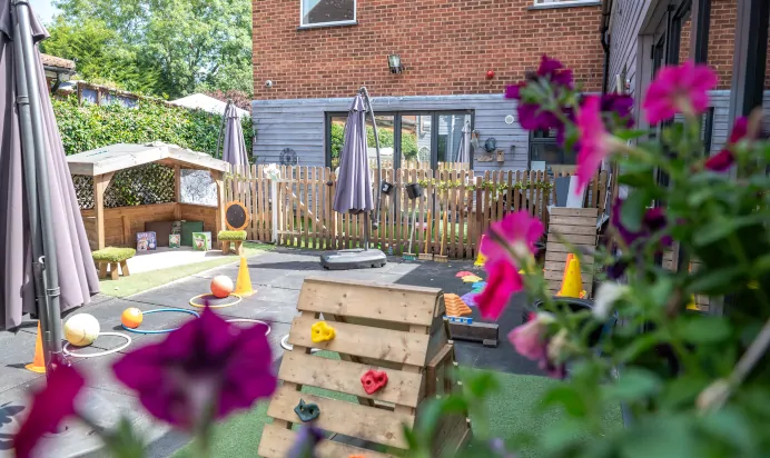 Outdoor play area with large umbrella at Dicky Birds Nursery Preschool Raynes Park London