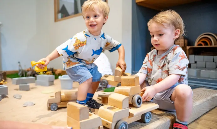 Two children playing in sand pit at Dicky Birds Nursery Preschool Raynes Park London
