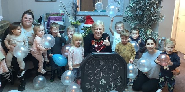 Nursery manager celebrating for a photo with the children
