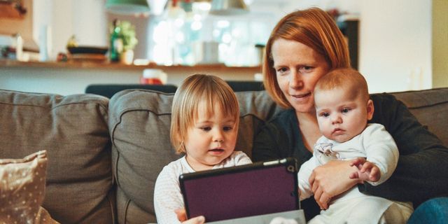 A photo of a mother and two young children on an ipad
