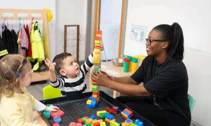 Child building tower with plastic bricks at The Winchmore Hill Day Nursery London