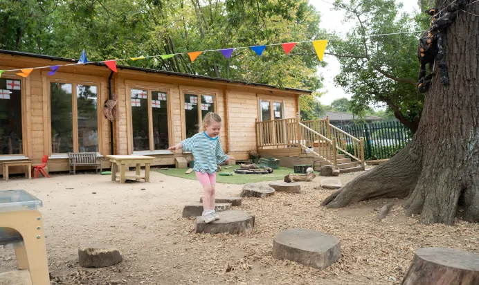 Child playing in outdoor play area at The Chingford Forest Day Nursery Preschool London