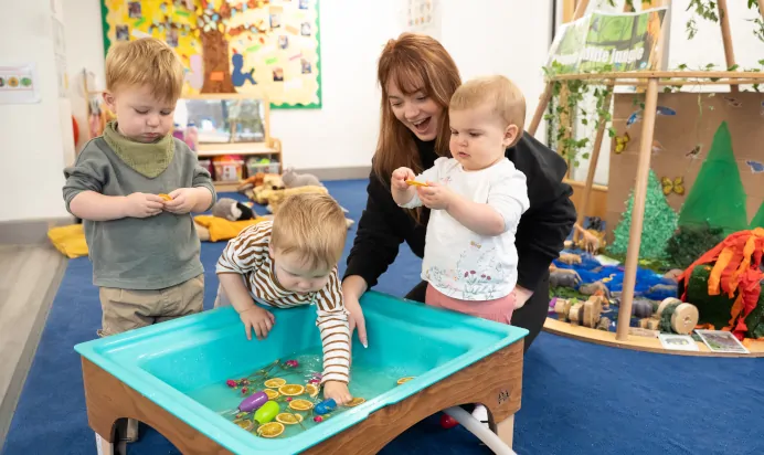 Child playing in water pit at The Winchmore Hill Day Nursery London
