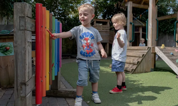Child playing musical instrument at The Penge East Day Nursery Preschool London
