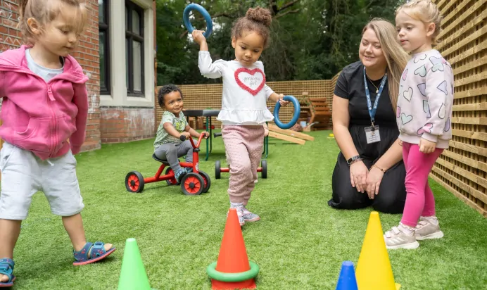 Child playing with keyworker in outside space at The Chingford Forest Day Nursery Preschool London