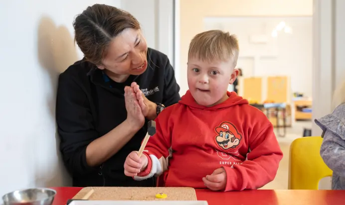 Child playing with toy hammer at The Ryan House Day Nursery Preschool Nottingham