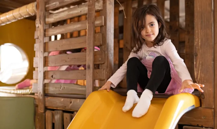 Child sitting on slide at The Chiswick House Day Nursery Preschool London