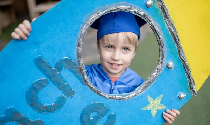 Child smiling while dressed up at The Penge East Day Nursery Preschool London