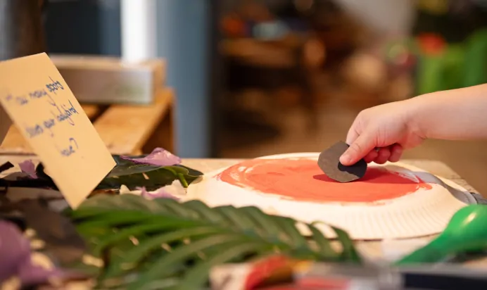 Child sticking paper to art at The Islington Square Day Nursery Preschool London