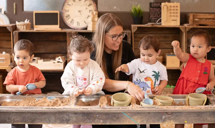 Children and key worker playing in sand pit at The Chiswick House Day Nursery Preschool London