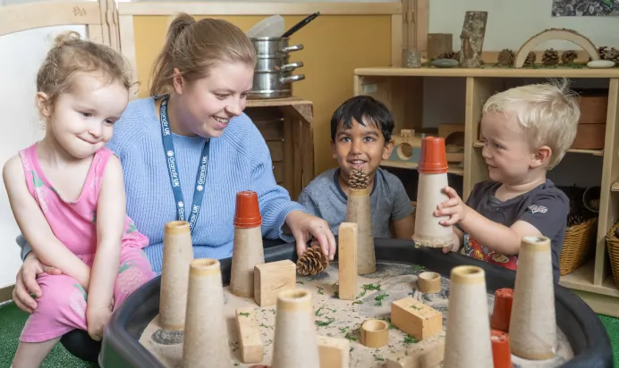 Children and key worker playing with sand at The Daydream Nursery Preschool Woking