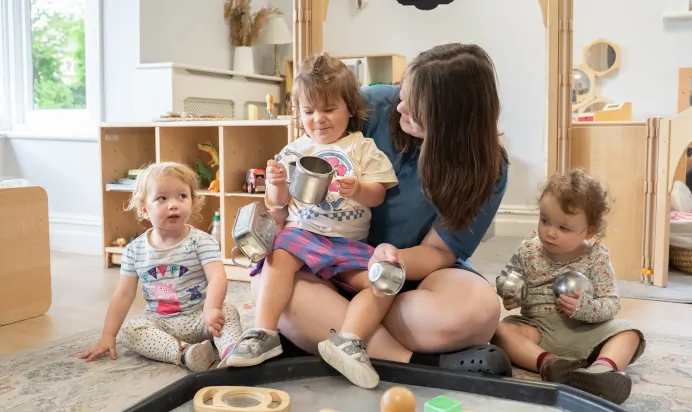 Children and key worker playing with water at The Daydream Nursery Preschool Woking
