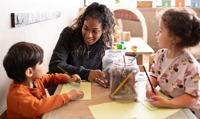 Children drawing with key worker at The Chiswick House Day Nursery Preschool London