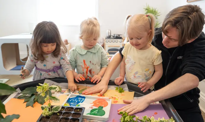 Children making handprint art at The Ryan House Day Nursery Preschool Nottingham
