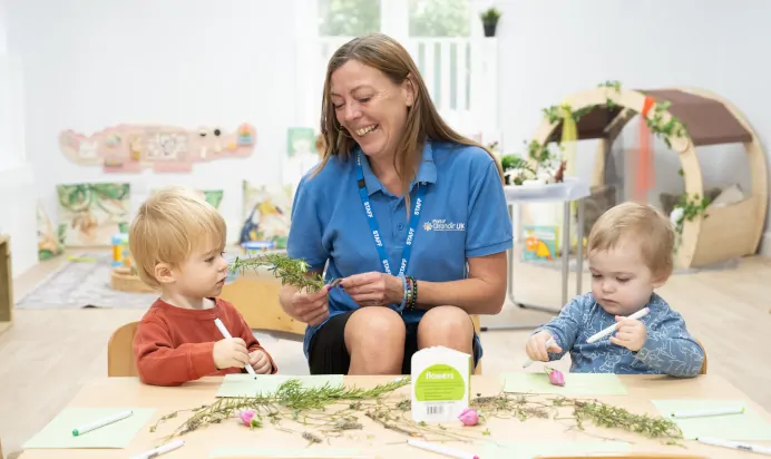 Children playing and smiling with key worker at The Chingford Forest Day Nursery Preschool London
