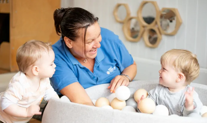 Children playing in a ball pit with key worker at Radcliffe On Trent Day Nursery Preschool