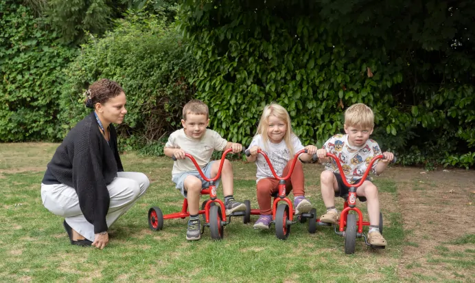 Children riding tricycle at The Daydream Nursery Preschool Woking
