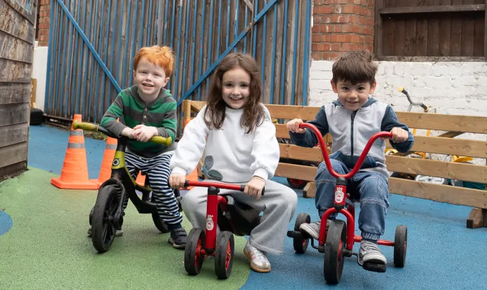 Children riding tricycles at The Winchmore Hill Day Nursery London