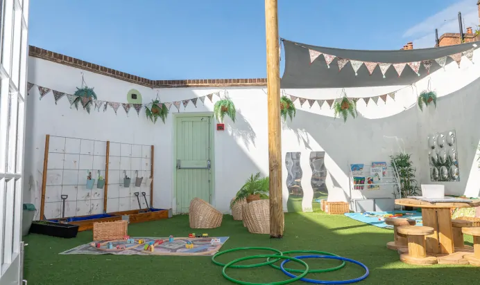 Garden area with wooden table at Clerkenwell Mount Day Nursery Preschool London