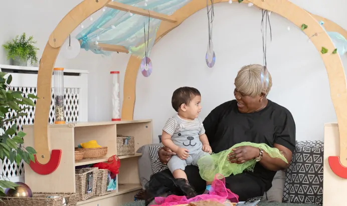 Key worker and child sitting in book corner at Clerkenwell Mount Day Nursery Preschool London