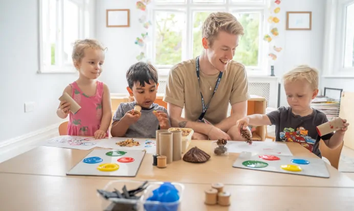 Key worker and children painting at The Daydream Nursery Preschool Woking