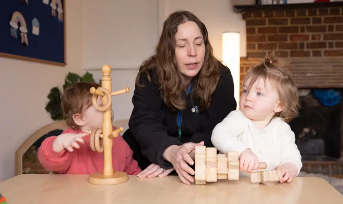 Key worker and children playing with wooden toys at The Harpenden Day Nursery Preschool