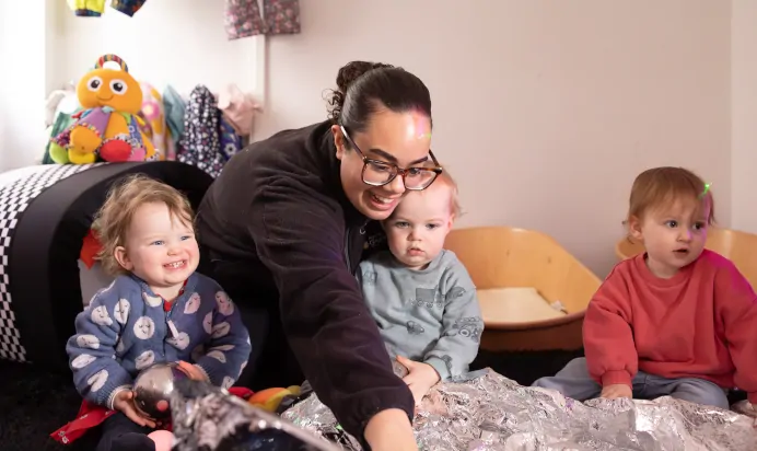 Key worker laughing with children inside at The Harpenden Day Nursery Preschool