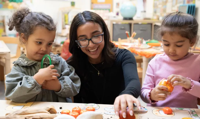 Key worker showing children how to prepare fruit at The Winchmore Hill Day Nursery London